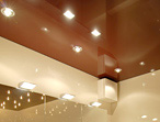 Ansicht eines elfenbeinfarbenen Badezimmers mit dunkelroter Hochglanzdecke mit integrierter Beleuchtung in Form verschiedener Spots